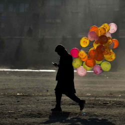 Un vendedor ambulante afgano que vende globos camina por un sendero en un terreno en el área de Chaman-e-Hozori en Kabul. Ahmad SAHEL ARMAN  | Foto:AFP