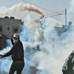 Un manifestante palestino usa una honda para devolver botes de gas lacrimógeno en medio de enfrentamientos con las fuerzas de seguridad israelíes en la aldea de KfarQaddum en la Cisjordania Jaafar. ASHTIYEH  | Foto:AFP