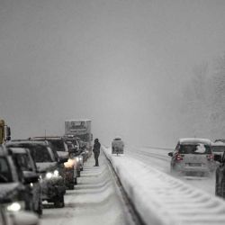 Un automovilista se encuentra entre vehículos atascados en un atasco debido a las fuertes nevadas, en la autopista A43 cerca de Albertville. JEFF PACHOUD  | Foto:AFP