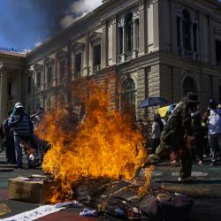 Integrantes de organizaciones sociales encienden fuego frente al Palacio Nacional durante una protesta, en el departamento de San Salvador, en El Salvador. | Foto:Xinhua/Alexander Peña