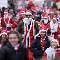 Niños y adultos, vestidos de Papá Noel, participan en la tradicional carrera benéfica anual de Papá Noel para recaudar fondos para las familias necesitadas de Kosovo, en Pristina. | Foto:ARMEND NIMANI / AFP