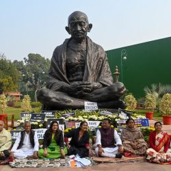 Los parlamentarios suspendidos de los partidos de la oposición participan en una protesta frente a la estatua de Mahatma Gandhi en la Casa del Parlamento en Nueva Delhi. | Foto:PRAKASH SINGH / AFP