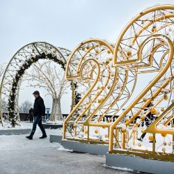 Un hombre pasa por delante de grandes números para el próximo año 2022, como parte de las decoraciones de Navidad y Año Nuevo en el punto de observación de las Colinas Vorobyovy en Moscú. | Foto:ALEXANDER NEMENOV / AFP