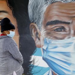Una mujer espera frente a un mural en el Instituto Nacional Cardiopulmonar, en Tegucigalpa, Honduras. | Foto:Xinhua/Rafael Ochoa