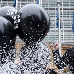 Activistas medioambientales llevan globos en los que se lee "se acabó el tiempo para el gas" mientras la UE presenta nuevos planes energéticos frente al edificio de la Comisión Europea en Bruselas. | Foto:KENZO TRIBOUILLARD / AFP