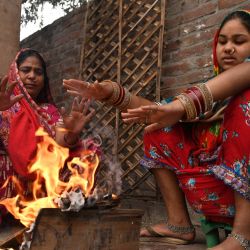 Mujeres se calientan alrededor de una hoguera en Amritsar, India. | Foto:NARINDER NANU / AFP