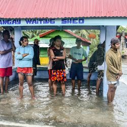 Los residentes permanecen en una zona inundada en la ciudad costera de Guiuan, en la provincia de Samar Oriental, en el centro de Filipinas, tras el paso del tifón Rai. | Foto:ALREN BERONIO / AFP