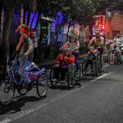 Personas discapacitadas son conducidas por voluntarios en bicicletas adaptadas construidas por la ONG "Te llevamos", por las calles de Envigado, cerca de Medellín, Colombia. | Foto:Joaquín Sarmiento / AFP