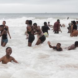 La gente se baña en el océano a lo largo del frente de la playa de la Milla de Oro de Durban, en medio del aumento de los casos diarios de Covid-19. | Foto:RAJESH JANTILAL / AFP