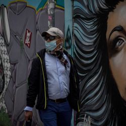 Un hombre camina frente a un mural en una calle, en Quito, capital de Ecuador. | Foto:Xinhua/Santiago Armas