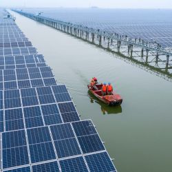 Vista aérea de empleados revisando una estación de energía fotovoltaica de 550 megavatios, en Wenzhou, en la provincia de Zhejiang, en el este de China. La estación de energía fotovoltaica en Wenzhou, que cubre un área de agua de 4,7 kilómetros, fue conectada con éxito a la red. El proyecto ha combinado la crianza pesquera y la generación de energía fotovoltaica. | Foto:Xinhua/Xu Yu