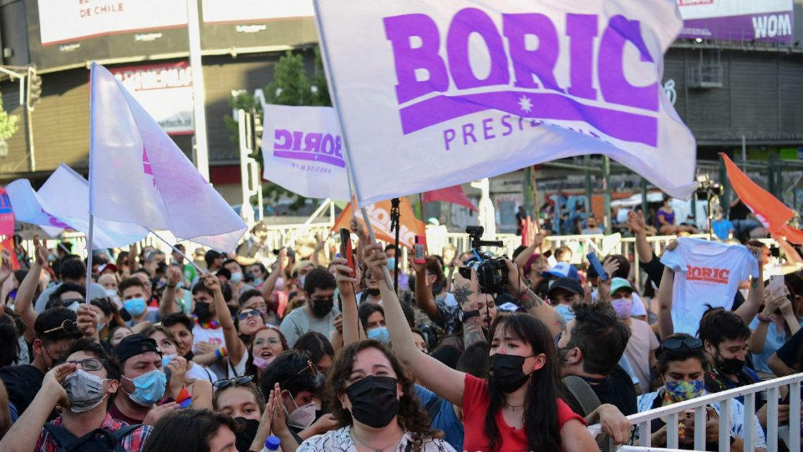 Supporters of Chilean presidential candidate Gabriel Boric, from the Apruebo Dignidad party, celebrate following the first official results of the run-off presidential election, in Santiago, on December 19, 2021.