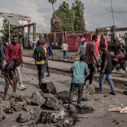 La gente retira piedras de una calle mientras la policía dispersa a las personas que levantan barricadas en Goma, al este de la República Democrática del Congo. - La gente respondió a un llamamiento de grupos de la sociedad civil para celebrar una manifestación en toda la ciudad para denunciar el aumento de la delincuencia. | Foto:Guerchom Ndebo / AFP