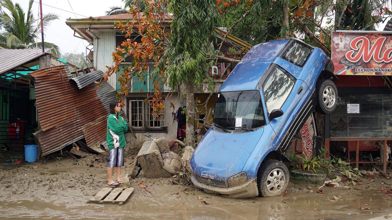 Una persona observa un vehículo arrastrado por las inundaciones provocadas por el súper tifón Rai en la ciudad de Loboc, provincia de Bohol, Filipinas. | Foto:CHERYL BALDICANTOS / AFP