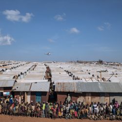 Cientos de desplazados se reúnen para un reparto de cubos y jabón en el campo de desplazados internos de Rhoo, a 60 kilómetros de Bunia, la capital provincial de Ituri, en el noreste de la República Democrática del Congo. | Foto:ALEXIS HUGUET / AFP