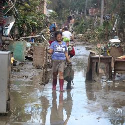 Los residentes limpian sus casas enlodadas causadas por las inundaciones debidas a las fuertes lluvias provocadas por el súper tifón Rai en la ciudad de Loboc, Filipinas. | Foto:CHERYL BALDICANTOS / AFP