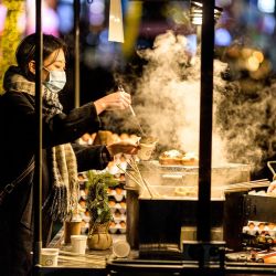 Los clientes compran bocadillos en un puesto ambulante de comida en Seúl, Corea Del Sur. | Foto:ANTHONY WALLACE / AFP