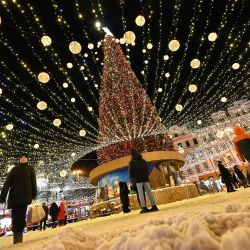 La gente visita una feria navideña en el centro de la capital ucraniana de Kiev durante una gélida tarde de invierno. | Foto:SERGEI SUPINSKY / AFP