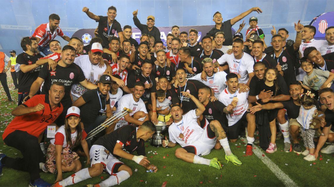 Barracas Central's players and staff celebrate after winning the penalty shoot-out and promotion to the top flight.