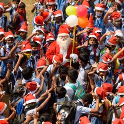 Fotogaleria Un hombre vestido de Papá Noel saluda a los niños en su escuela para celebrar la Navidad en Chennai, India. | Foto:ARUN SANKAR / AFP