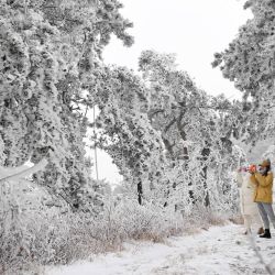 Imagen de turistas tomando fotografías del paisaje nevado en el punto escénico de la montaña Lushan, provincia de Jiangxi, en el este de China. | Foto:Xinhua/Wan Xiang