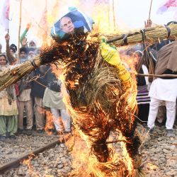 Los agricultores queman una efigie del ministro de Agricultura de la India, Narendra Singh Tomar, mientras bloquean las vías del tren durante una manifestación en la que exigen compensaciones y puestos de trabajo para las familias de los fallecidos durante las protestas contra las reformas agrícolas del gobierno central, en las afueras de Amritsar, India. | Foto:NARINDER NANU / AFP