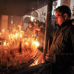 Milad Ayyad, cristiano ortodoxo griego palestino de Gaza, enciende velas en la basílica griega de la Iglesia de la Natividad, el lugar tradicional del nacimiento de Cristo, en la ciudad bíblica de Belén, en la Cisjordania ocupada. | Foto:HAZEM BADER / AFP