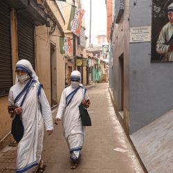 Monjas caminan cerca de la entrada de la sede de las Misioneras de la Caridad en Calcuta, India. | Foto:AFP