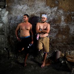 Dos iniciados de la sociedad religiosa secreta masculina conocida como Abakua descansan tras participar en la ceremonia de juramento de la "potencia" Efi Barondi Cama en el barrio de Simpson, en Matanzas, Cuba. | Foto:YAMIL LAGE / AFP