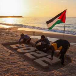 Jóvenes palestinos esculpen el número 2022 en la arena al atardecer antes de la Nochevieja, en la playa de la ciudad costera mediterránea de Gaza. | Foto:MOHAMMED ABED / AFP