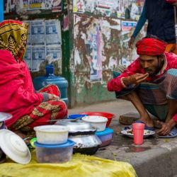 Fotogaleria Una mujer que vende comida cocinada atiende a un cliente en un sendero junto a una calle muy transitada en Dhaka, Bangladesh. | Foto:Jewel Samad / AFP