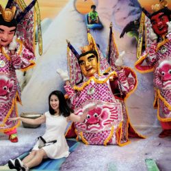 Una mujer posa para las fotos con las efigies del dios taoísta "Tercer Príncipe" durante una exposición llamada "Amazing Taiwan 3D Art Exhibition II" organizada por el Ministerio de Cultura en el Chiang Kai-shek Memorial Hall en Taipei, Taiwan. | Foto:Sam Yeh / AFP