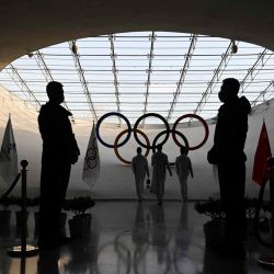 Los guardias de seguridad están esperando mientras los trabajadores repostan la llama olímpica en la Torre Olímpica en Beijing , un mes antes de la inauguración de los Juegos Olímpicos de Invierno de 2022 el 4 de febrero de 2022 | Foto:AFP