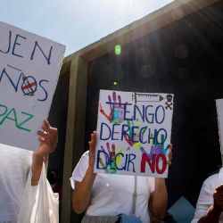 La gente sostiene carteles que dicen "Dejen a los niños en paz" y "Tengo derecho a decir no" durante una manifestación contra la vacunación obligatoria COVID-19 para niños en San José, Costa Rica.  | Foto:AFP