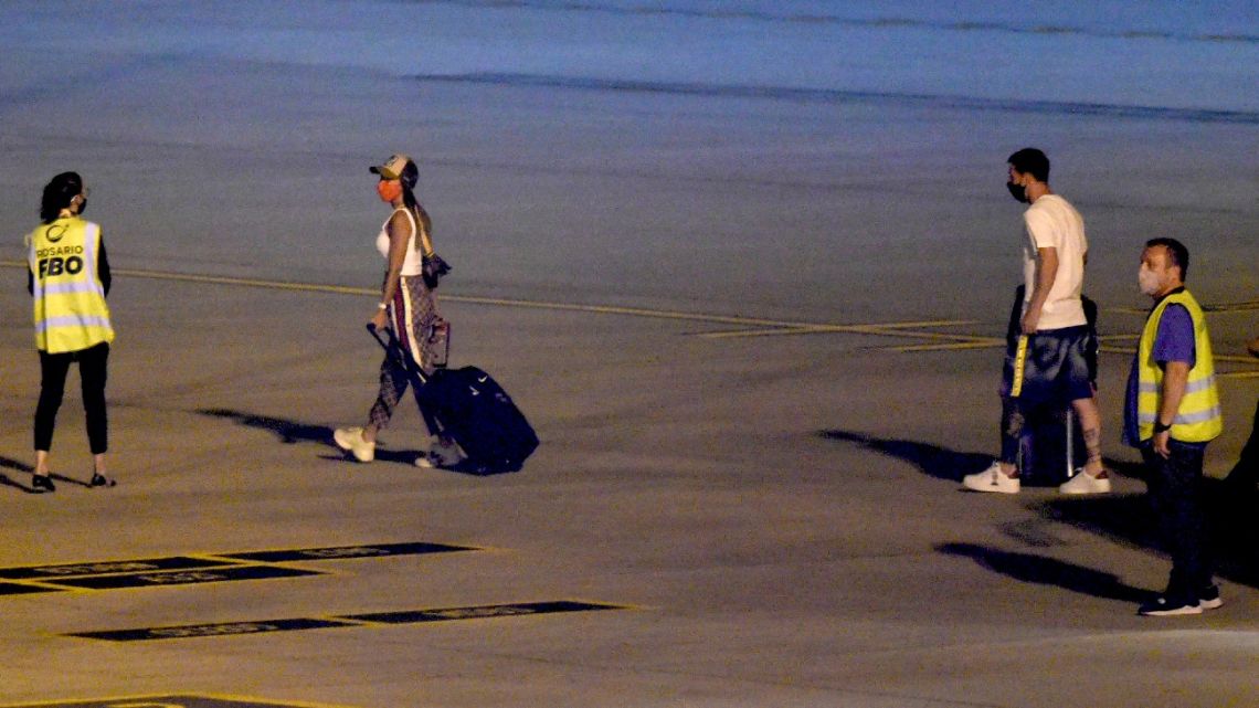 Lionel Messi and his wife Antonella Roccuzzo arrive to board a plane bound for Paris, at Islas Malvinas airport in Rosario, in the Argentine province of Santa Fe, on January 5, 2022. Lionel Messi tested positive for Covid-19 while on holiday in his hometown of Rosario in Argentina. 
