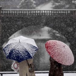 Una pareja sostiene su paraguas mientras cae nieve cerca del Palacio Imperial en Tokio.  | Foto:AFP