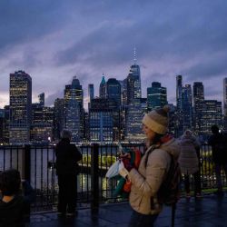 La gente toma fotos del horizonte del bajo Manhattan durante la puesta de sol en la ciudad de Nueva York | Foto:AFP