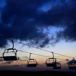Las góndolas vacías de un telesilla se ven al anochecer en la estación de esquí de Oberhof, en el este de Alemania. La copa mundial de biatlón de este año en Oberhof se llevará a cabo sin espectadores. | Foto:AFP
