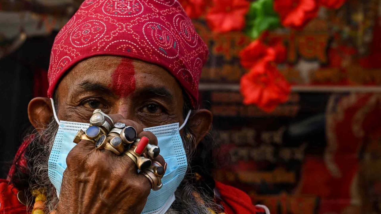 Un peregrino usa una máscara facial que observa los protocolos de seguridad del coronavirus Covid-19 en un campamento de tránsito antes de la próxima ceremonia religiosa anual GangasagarMela en la isla Sagar, en Calcuta.  | Foto:AFP