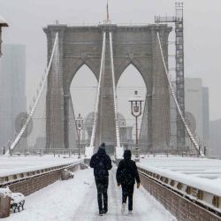 La gente cruza el Puente de Brooklyn durante la tormenta de nieve de la temporada en la ciudad de Nueva York.ANGELA WEISS / AFP | Foto:AFP
