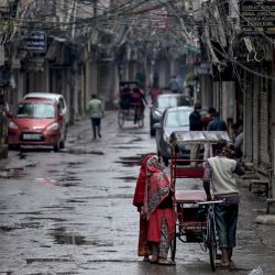 Algunos peatones caminan por una calle parcialmente desierta con las tiendas cerradas a ambos lados en los barrios antiguos de la ciudad amurallada, Delhi durante un toque de queda de fin de semana en curso impuesto por la directiva del gobierno de Delhi para frenar la propagación del coronavirus Covid-19 en Nueva Delhi, India. | Foto:MONEY SHARMA / AFP
