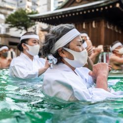 Los creyentes sintoístas del santuario Teppozu Inari se bañan en agua fría para purificar sus almas y cuerpos durante un ritual de Año Nuevo en Tokio. | Foto:Philip Fong / AFP