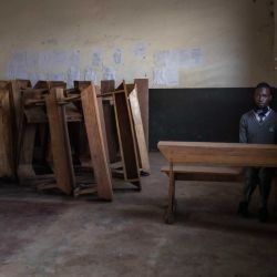 Un estudiante se sienta solo en un aula tras volver a la escuela en el primer día de reapertura tras un cierre de casi dos años de los centros de enseñanza como parte de las medidas gubernamentales para frenar la propagación del Covid-19 en Kampala, Uganda. | Foto:BADRU KATUMBA / AFP