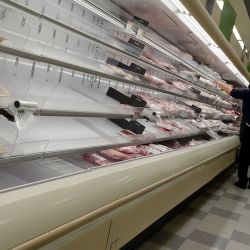 Los estantes que exhiben carne están parcialmente vacíos mientras los compradores se abren paso en un supermercado en Miami, Florida. La variante del coronavirus Omicron sigue perturbando la cadena de suministro causando algunos estantes vacíos en las tiendas. | Foto:Joe Raedle/Getty Images/AFP