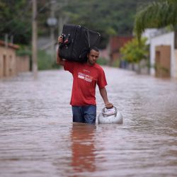 Un hombre vadea el agua mientras saca las pertenencias de su casa en el inundado municipio brasileño de Juatuba, situado en el estado de Minas Gerais, después de las lluvias extremadamente fuertes que han caído en los últimos días en el sureste del país. | Foto:DOUGLAS MAGNO / AFP