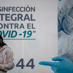 Una mujer hace cola para hacerse la prueba o inocularse contra la enfermedad del coronavirus COVID-19 en un centro de salud situado en la calle en Lima, Perú. | Foto:ERNESTO BENAVIDES / AFP