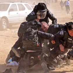 La policía israelí detiene a un hombre mientras los beduinos protestan en el pueblo de Sa'we al-Atrash, en el sur de Israel, en el desierto de Neguev, contra un proyecto de forestación del Fondo Nacional Judío. | Foto:AHMAD GHARABLI / AFP