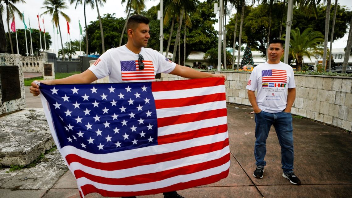 Colombian Francisco Landínez (left), member of the Oppressed Veterans Foundation, which seeks that Latin American contractors obtain the same benefits as pensioners from US wars, holds a US flag during a gathering in Miami, Florida, on November 20, 2021. 