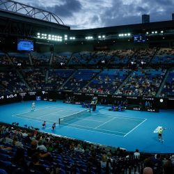 El público observa cómo el alemán Alexander Zverev golpea una devolución contra el alemán Daniel Altmaier durante su partido individual masculino en el primer día del torneo de tenis del Abierto de Australia en Melbourne. | Foto:BRANDON MALONE / AFP