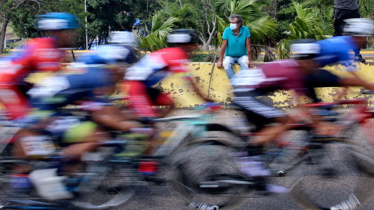 Una persona observa a los ciclistas del pelotón durante la primera etapa de la 57ª Vuelta al Táchira en Bicicleta, en San Cristóbal, Estado de Táchira, Venezuela. | Foto:Jhonny Parra / AFP